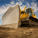 A large yellow bulldozer at a construction site low angle view