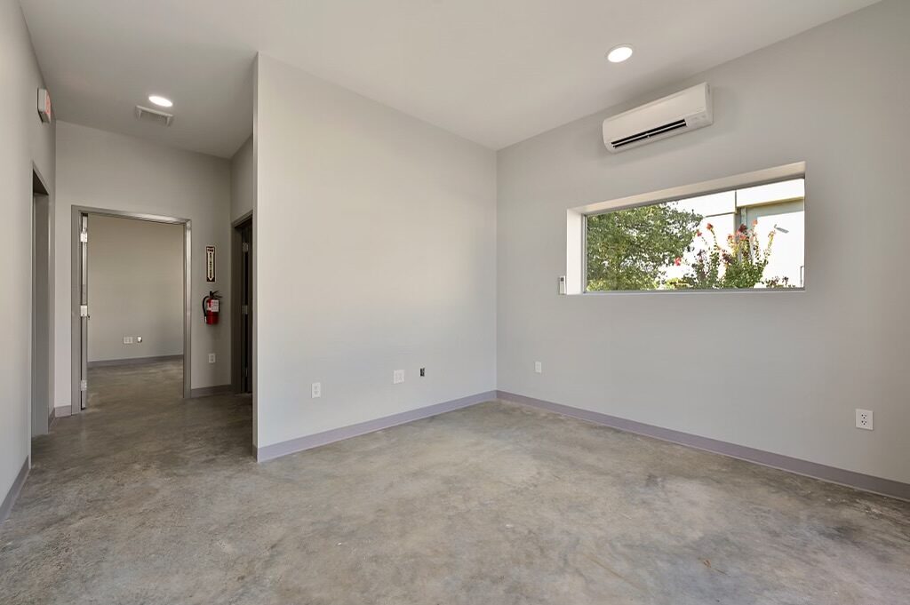 Office with a mini-split, long clerestory window and doorways through to the corridor