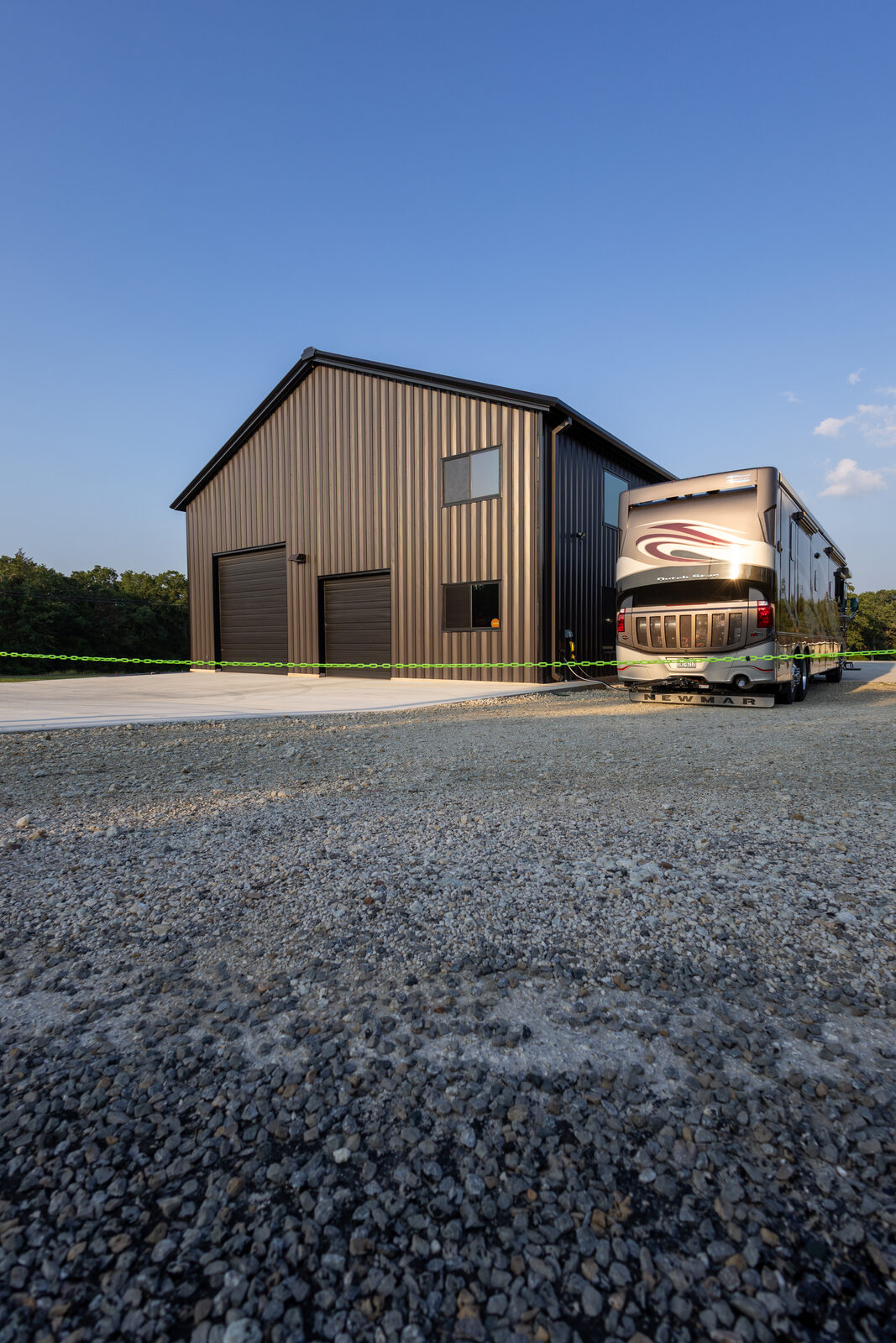 Two oversized overhead doors on the shop end with a motorhome parked outside