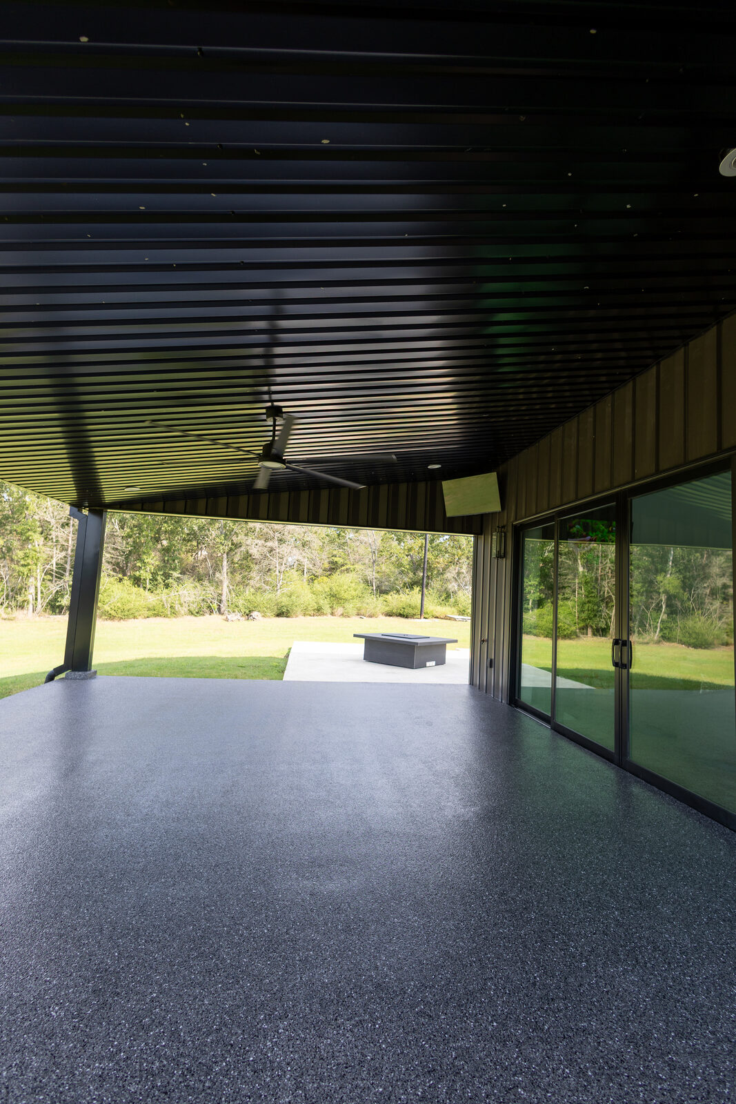 Covered patio with an epoxy floor, ceiling fan and sliding glass doors onto the living space