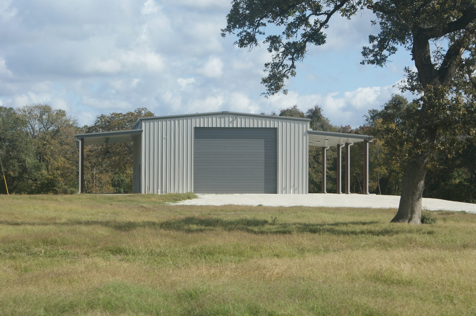 40 by 60 metal building in Franklin, Texas with a 20 foot by 16 foot overhead door on the end wall and lean-tos on both sides