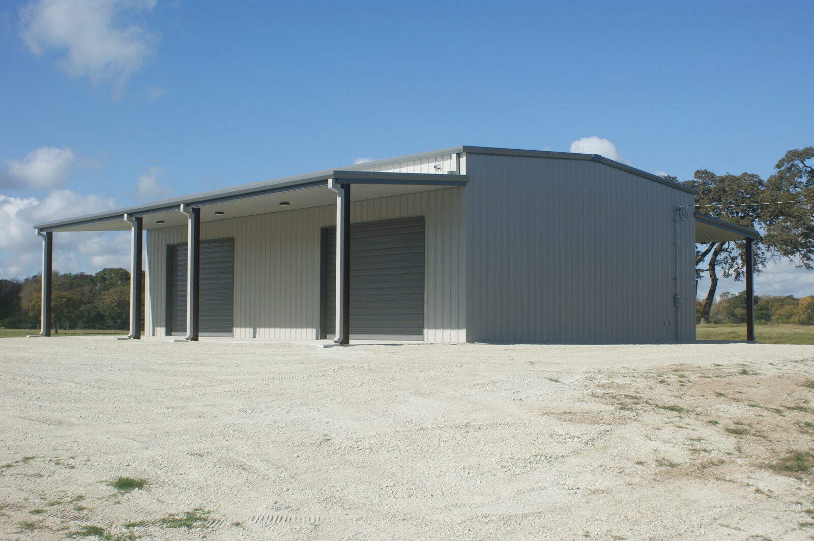Sidewall of the Franklin metal building with two 16 foot by 12 foot overhead doors under an open lean-to