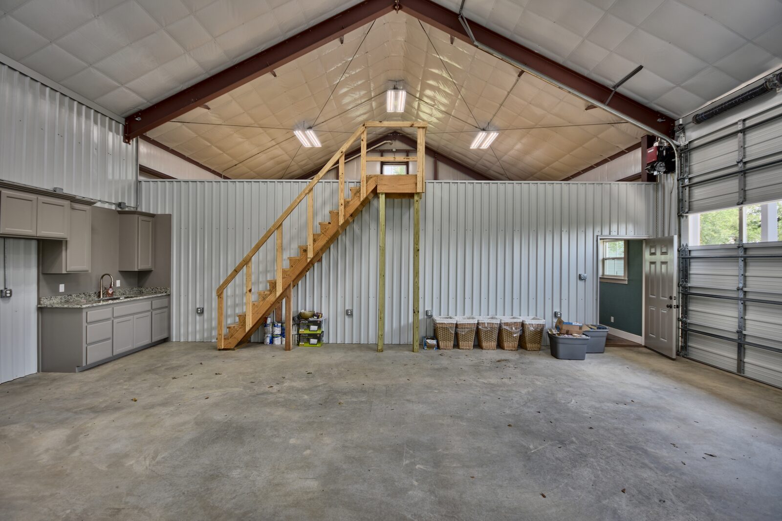 Shop interior with a timber stair to a loft and a vaulted insulated ceiling