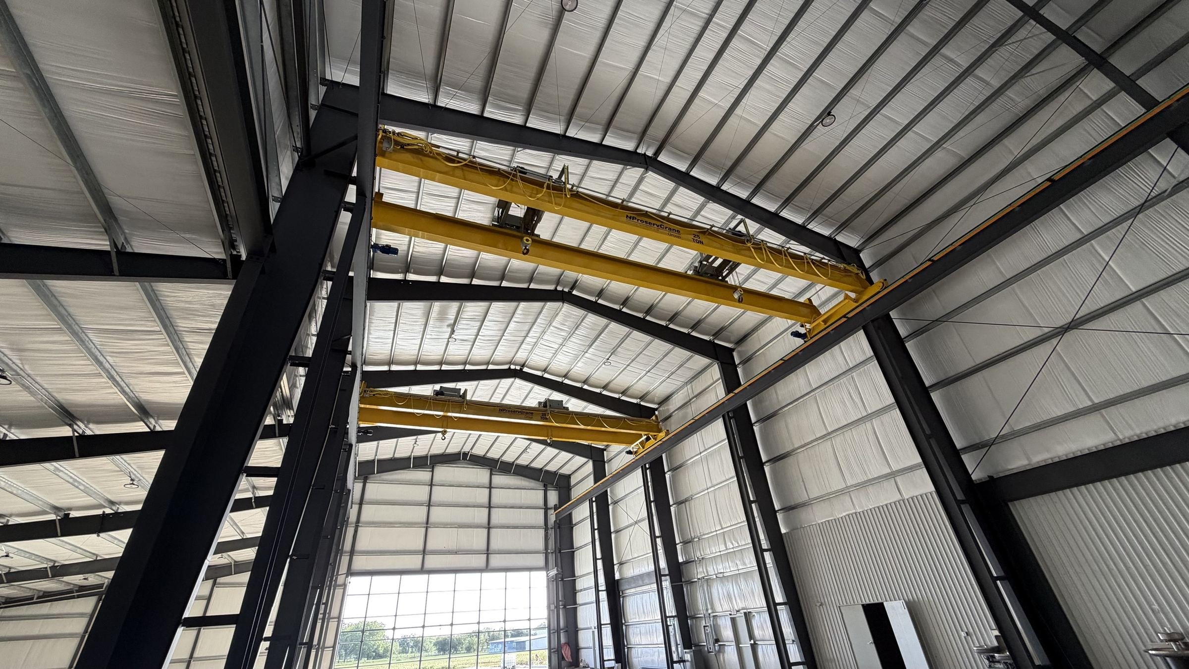 Interior of a Rhodes Building Systems industrial building with twin overhead cranes on a clear-span steel frame